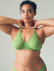 A model wearing the Tamara Bralette in light green stretch lace.