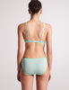 Back of woman in light green cotton bralette and panty