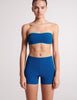 On model image of front view of blue bandeau and blue swim shorts