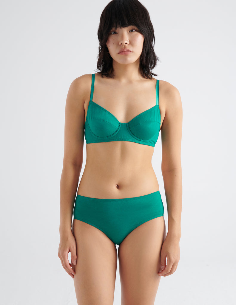 Front view image of model wearing green recycled organic cotton underwire bra and matching bottom