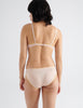 Back image of model wearing peach colored  cotton crepe underwire bra with matching panties. 