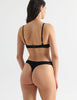 Back of Woman in black cotton and silk bralette and thong