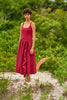 woman in grassy area wearing red one piece and matching skirt. 