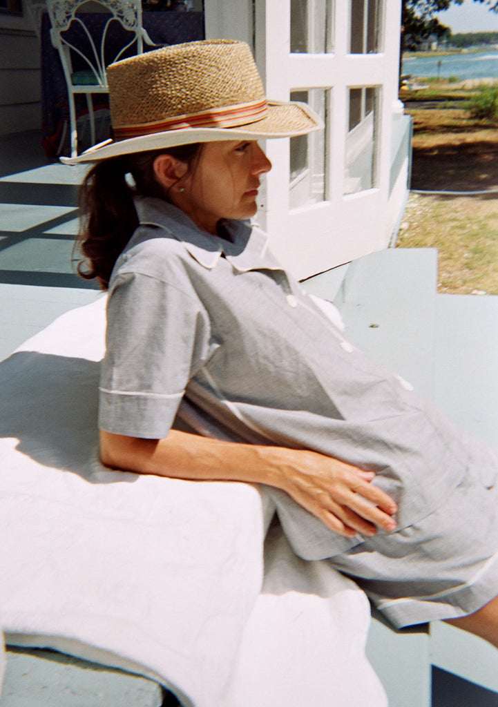 Woman wearing light grey sleep shirt with contrast piping and matching shorts