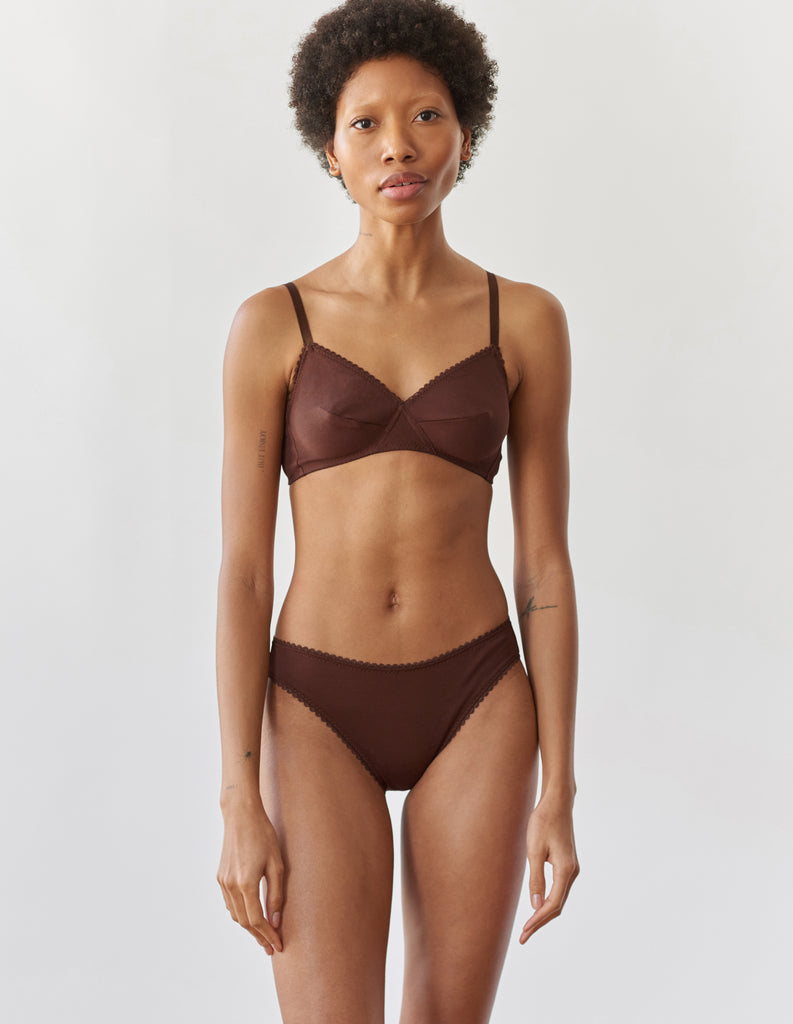 A woman wearing the brown cotton Antonia Bralette and Isabella cotton panty.