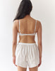 A back view of A woman wearing a white bra with white cotton boxer shorts.