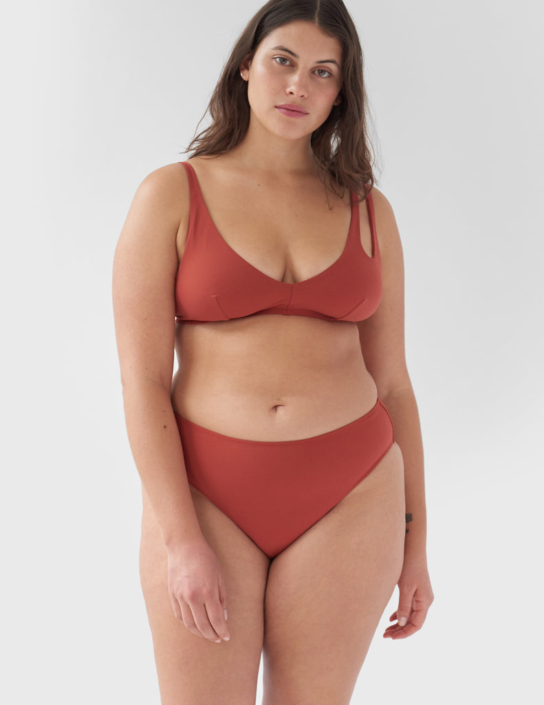 Front view of woman wearing a red bikini bottom with matching red bikini top