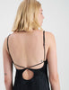 A back shot of A woman wearing a black silk slip.