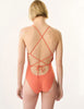 Back view of the Jada One Piece swimsuit in orange worn by a model.
