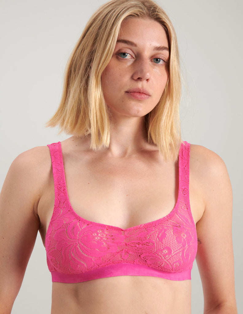 A woman wearing a bright pink lace bralette.