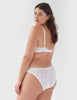 Back view of woman wearing white, lace underwire bra and matching mid-rise panty.