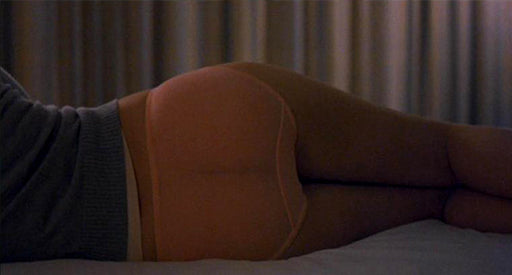 Back view of a woman in pink underwear and a blue shirt.