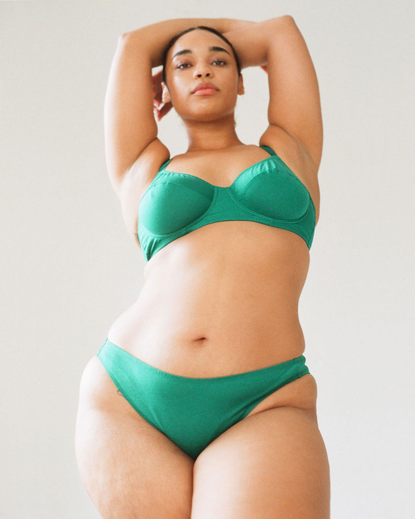 A model wearing the Josie panty and Beau Underwire bra in emerald green cotton