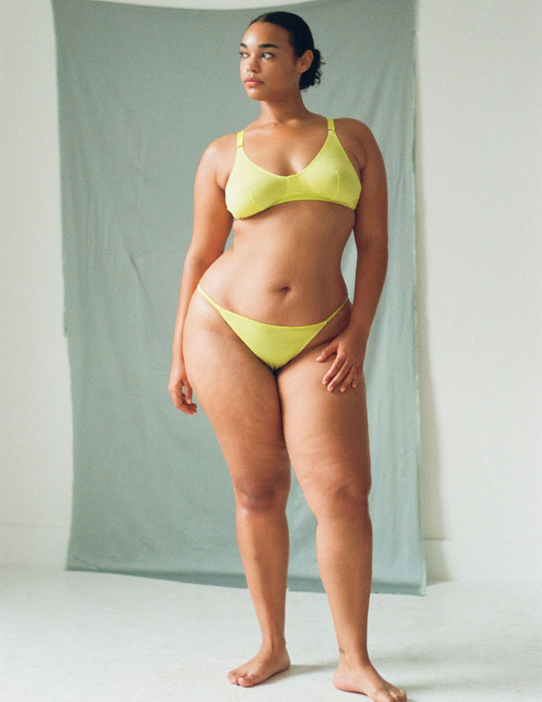 A model wearing the Briar Bralette and Bisoux Panty in bright yellow cotton.