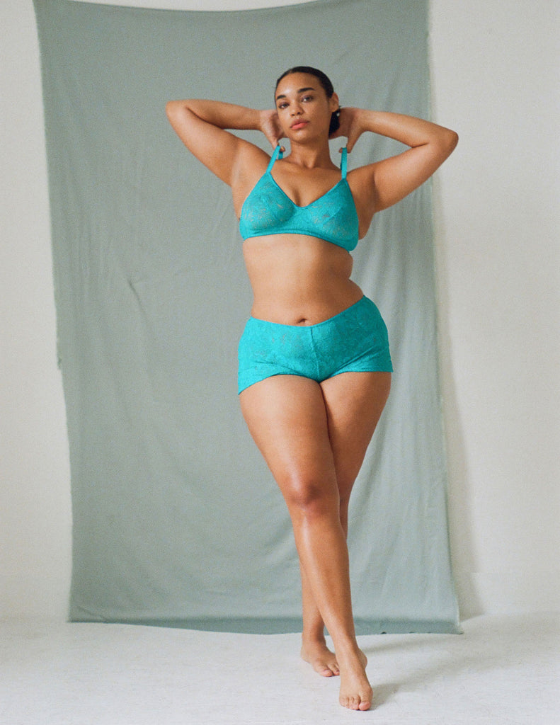 A model wearing the tamara bralette in turquoise lace