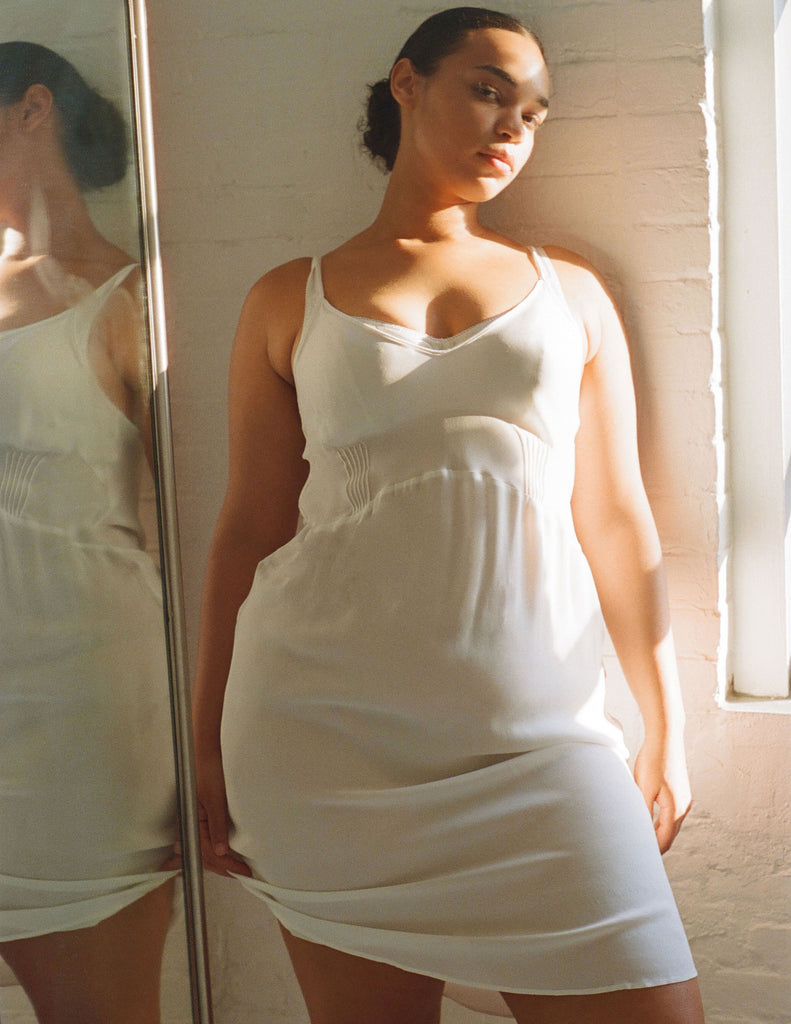 A model wearing the Cadel Slip Dress in white silk