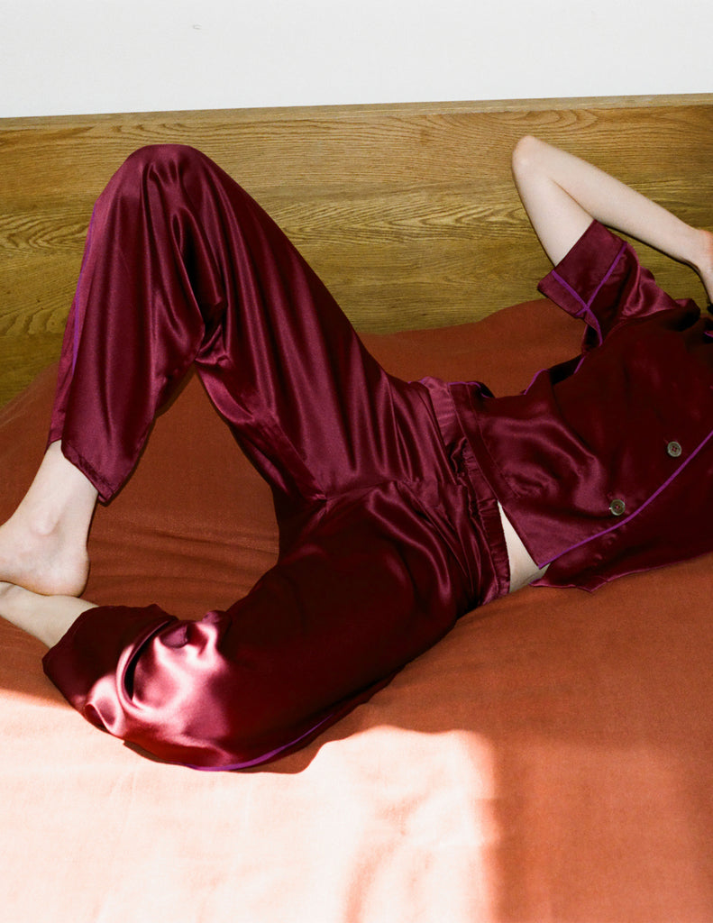 Model wearing Araks Shelby silk pajama top with the Viktoria pajama bottoms in Garnet