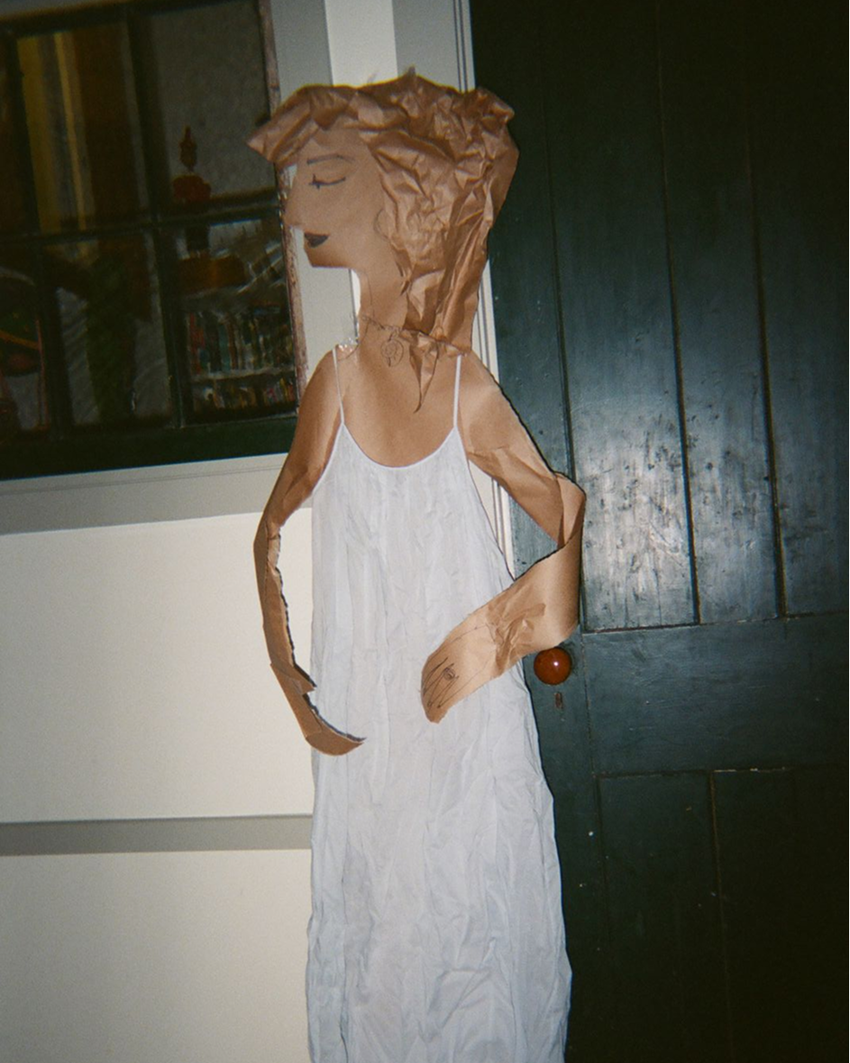 Mannequin wearing a white dress with a dark background