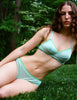 front shot lifestyle image of woman wearing green cotton bra and panty