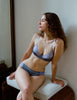 On model, editorial image of blue cotton with purple silk bralette and blue cotton with purple silk panty.
