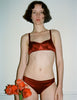 A model wearing the Gita Underwire Bra and Gwyneth Panty in dark orange silk