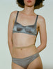 A model wearing the Gita Bra and Gwyneth Panty in grey silk.