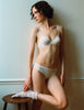 A model wearing the Sofia Underwire Bra and the Isabella Panty in white cotton. 