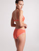 three quarter back view of woman in orange bra and panty