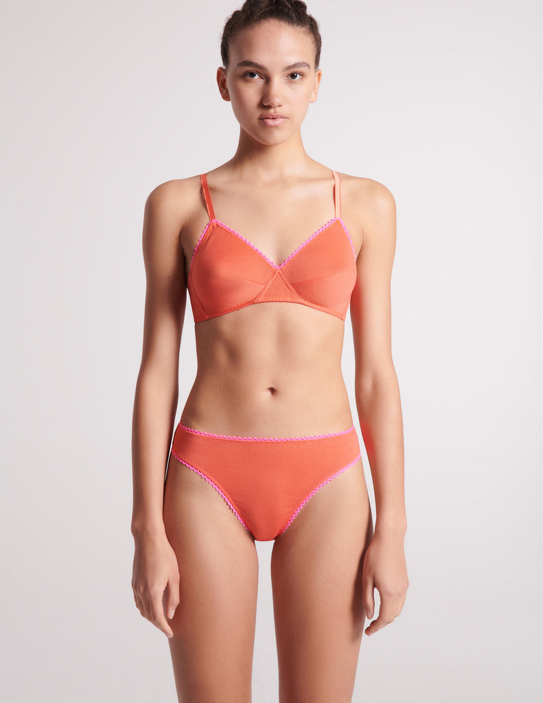front view of woman in orange bra and thong