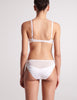 On model image of backside of white silk bralette and panty