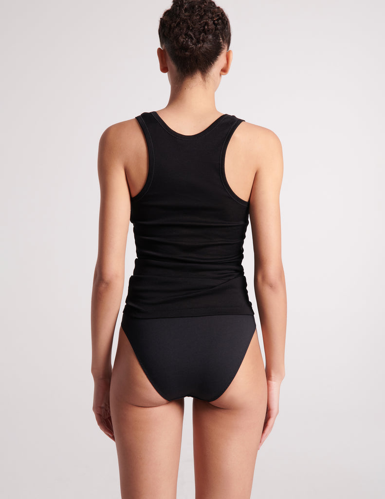 back of woman in black cotton tank and panty