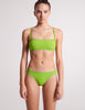 On model image of green bikini bottoms and bandeau top with straps