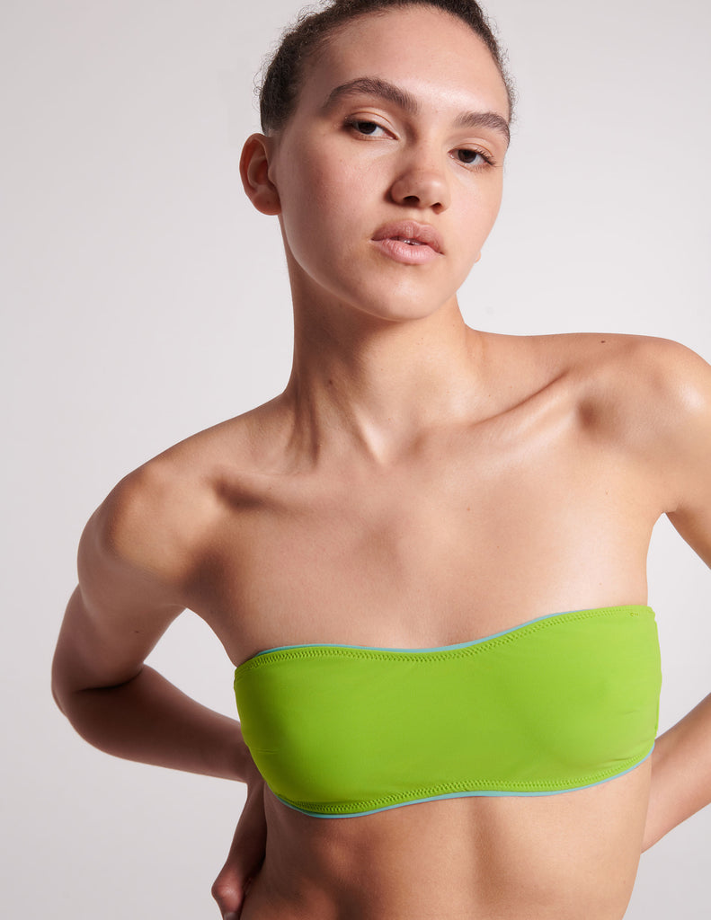 On model, 3/4 image of green bandeau bikini top