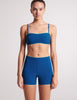 On model image of blue bandeau top with straps and matching shorts