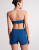 On model image of back view of blue bandeau and blue swim shorts
