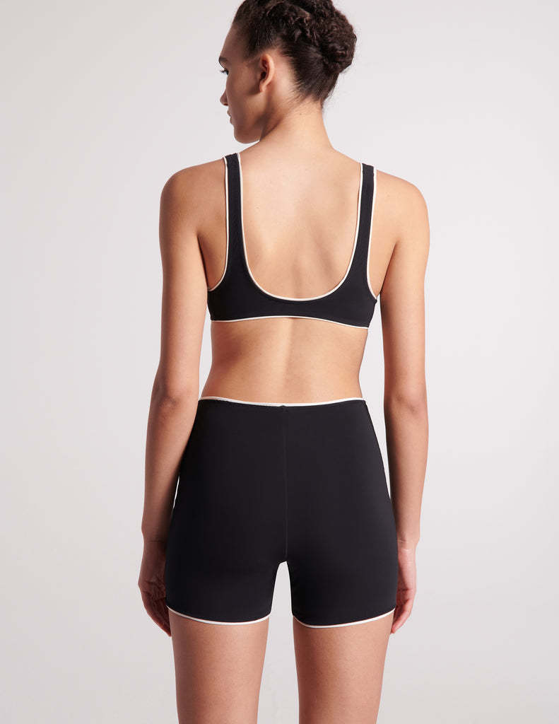 Back-side, on-model image of black swim short and black swim top