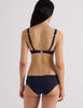 Model wearing Araks Ulija bikini top and Ezra bikini bottoms in navy with red polka dots