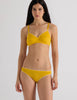 A model in the araks organic cotton antonia bralette and isabella panty in pomelo yellow