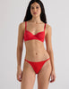 A model in the araks beau underwire bra and bisoux panty in recycled cotton in scarlet red