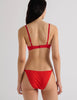 A model in the araks beau underwire bra and bisoux panty in recycled cotton in scarlet red