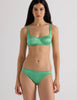 A model in the araks silk charmeuse penelope bralette and gwyneth panty in cypress green