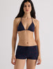 Model wearing Araks Nelle bikini top and Polly swim shorts in navy with red polka dots