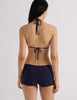 Model wearing Araks Nelle bikini top and Polly swim shorts in navy with red polka dots