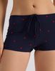 Model wearing Araks Nelle bikini top and Polly swim shorts in navy with red polka dots