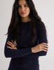 Model wearing Araks Undine rashguard with Polly swim shorts in navy with red polka dots