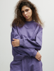 A model posing in the Araks Valerie crewneck in the shade Violette against a white background.