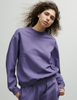 A model posing in the Araks Valerie crewneck in the shade Violette against a white background.