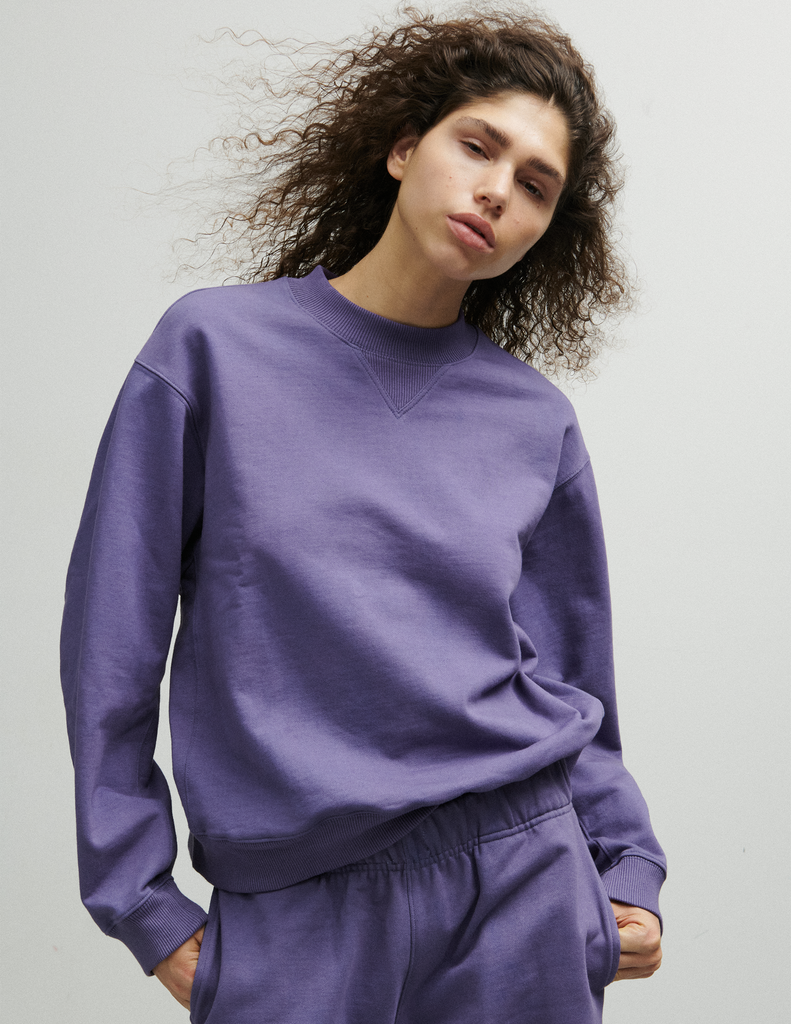 A model posing in the Araks Valerie crewneck in the shade Violette against a white background.