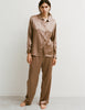 A woman wearing an Araks Suki silk pajama top with Viktoria silk bottoms in Terra