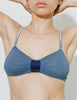 A close-up of a model wearing the Araks Uma bralette in Shadow